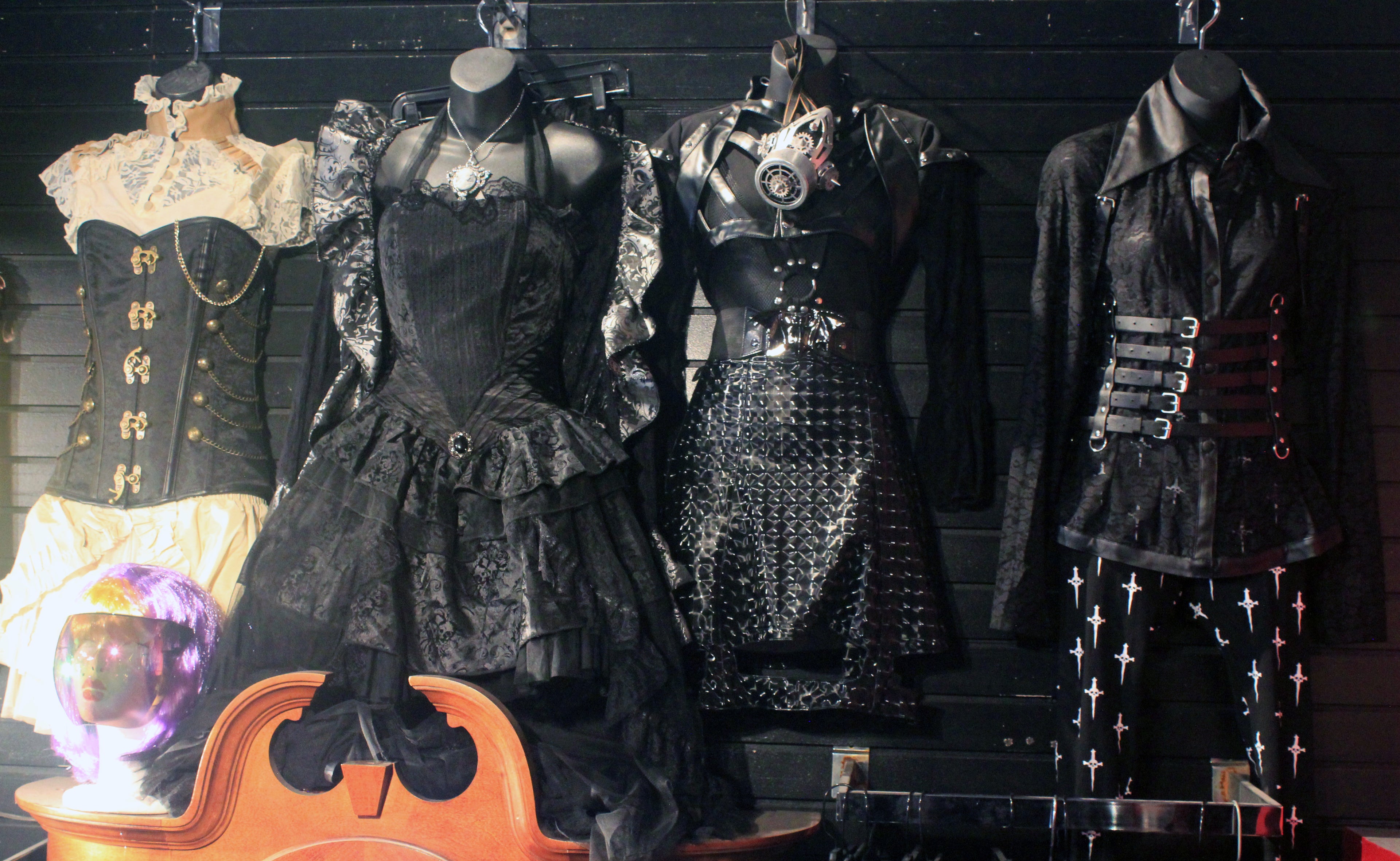 Various gothic outfits in NYC goth store, including a steampunk corset and gasmask